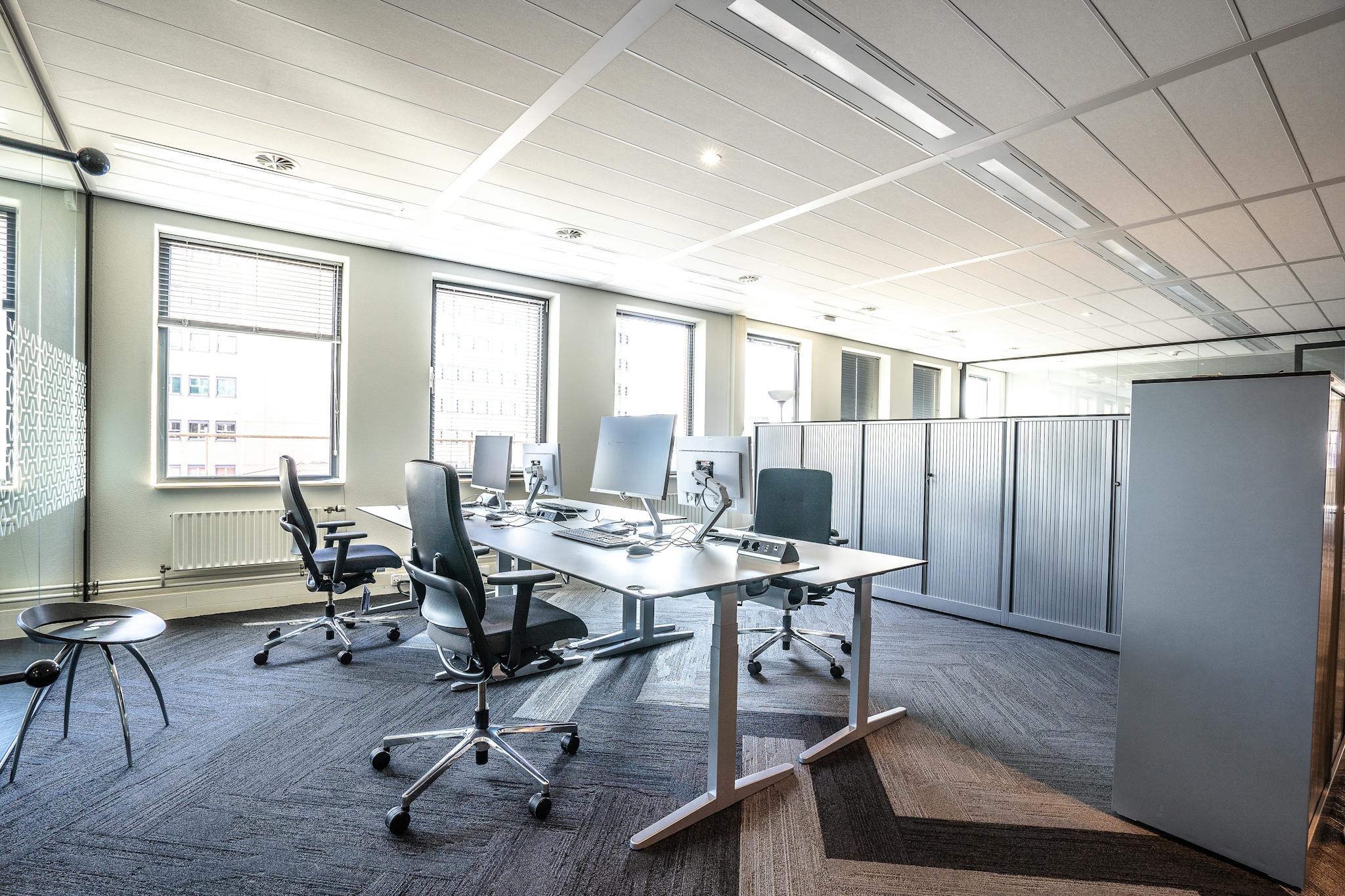 Photo by Mike van Schoonderwalt - SITWELL Bright and spacious modern office interior featuring sleek workstations and ergonomic chairs.